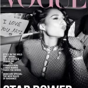 Könnte beinhalten: Schwarz-Weiß-Cover des Vogue-Magazins mit einer Frau, die einen Kuss gibt. Der Magazintitel "VOGUE" ist rosa. Das Cover zeigt den Text "STAR POWER" und "RAYE finds her LIGHT". Ein handgeschriebenes Schild lautet "I LOVE YOU RAYE."
