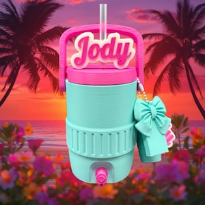 May include: A teal and pink insulated water cooler with the name "Jody" in a cursive font. The cooler has a handle, a straw, and a teal bow with a tag. The background features a tropical sunset and palm trees.