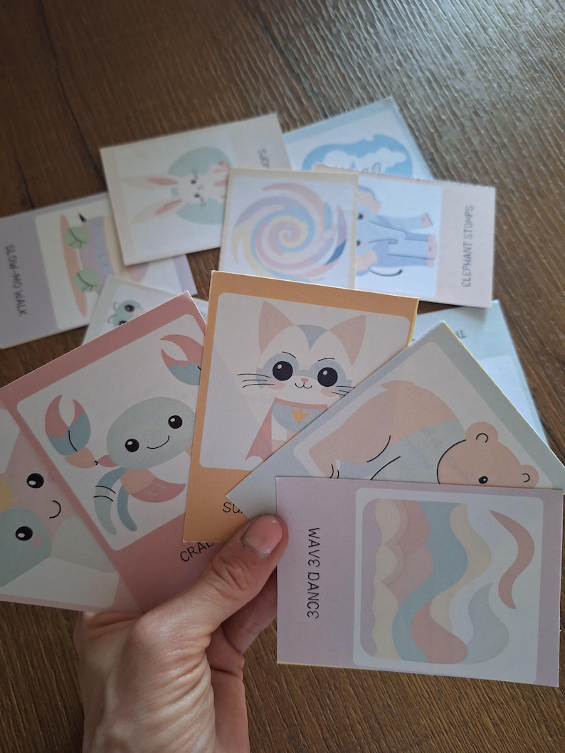 May include: A set of colorful illustrated cards featuring various animals and designs. The cards include a crab, a cat, a wave, a turtle, a bunny, a lollipop, an elephant, and a bear. The cards are perfect for a variety of craft projects, including scrapbooking, card making, and journaling.