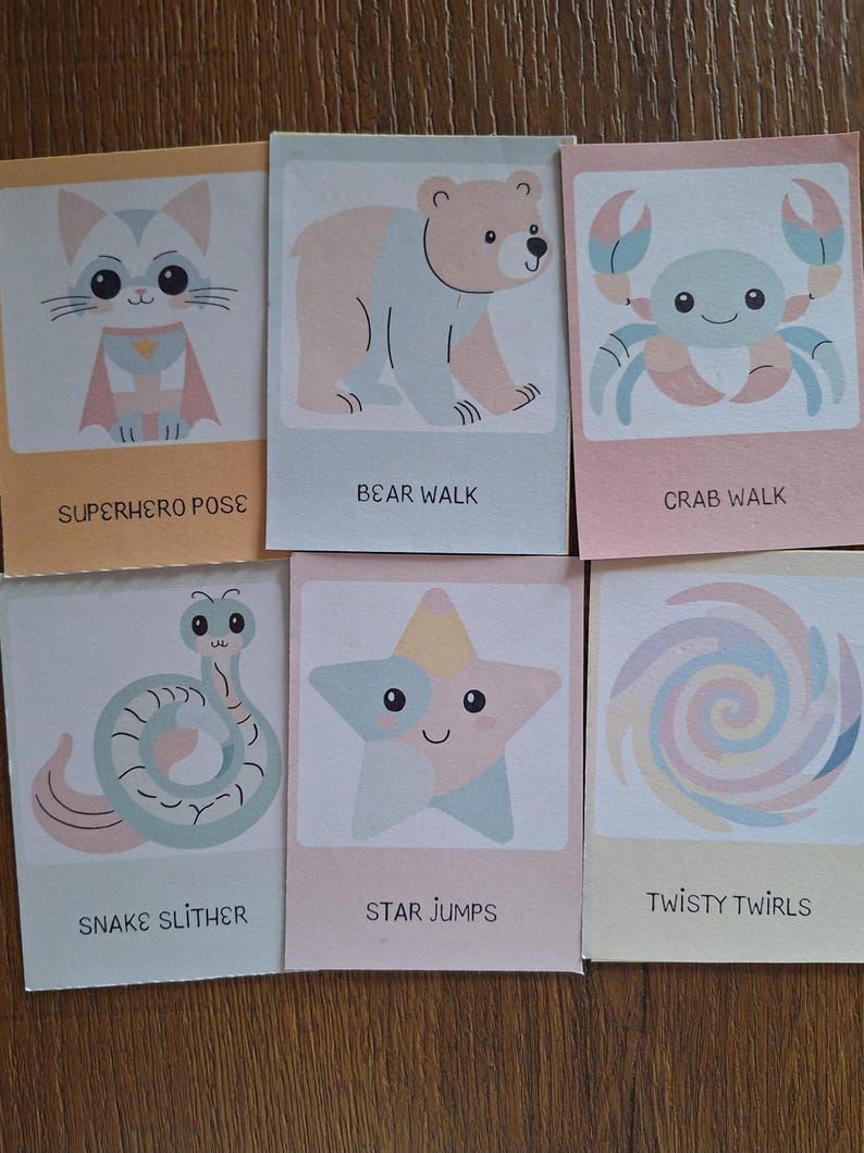 May include: Six colorful cards with illustrations of a cat, bear, crab, snake, star, and a swirl. Each card has a title: Superhero Pose, Bear Walk, Crab Walk, Snake Slither, Star Jumps, and Twisty Twirls.