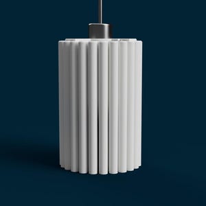 May include: A white, cylindrical pendant light fixture with vertical, fluted sides. The light hangs from a thin, silver-colored cord against a dark blue background. The design is minimalist and modern, suitable for interior lighting.