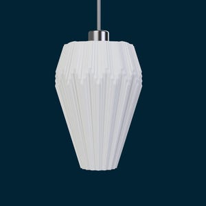 May include: White pendant light fixture with a geometric, textured shade. The shade has a cone-like shape with vertical lines and a silver-colored metal top. The light hangs from a thin, silver-colored wire against a dark blue background.