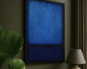 May include: A framed abstract painting with a dark blue rectangular shape against a lighter blue background. The artwork hangs on a dark green wall. A table lamp with a gray shade and a beige ceramic base sits on a wooden table. A decorative bowl and a plant are also on the table.