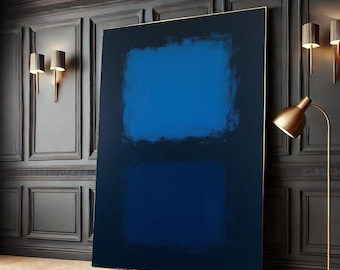 May include: Abstract painting with two squares of blue paint on a black background. The painting is framed in gold and hanging on a dark wall.