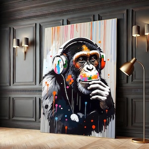 May include: A colorful painting of a chimpanzee wearing headphones. The chimpanzee is looking to the side and has a thoughtful expression. The background is a light gray with colorful paint splatters.
