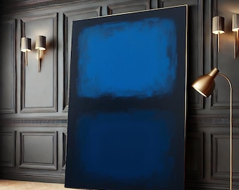 May include: Abstract painting with two horizontal bands of blue paint. The top band is a lighter shade of blue than the bottom band. The painting is framed in a thin gold frame and is hanging on a dark wall.