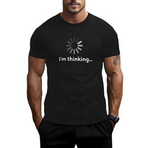 Op de afbeelding: Een zwart T-shirt met een wit laadpictogram en de tekst "I'm thinking..." gedrukt op de voorkant.