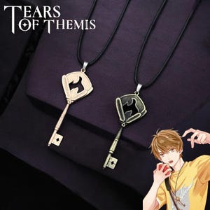 Puede incluir: Dos collares con llaves doradas y cadenas de cordón negro. Las llaves tienen un diseño estilizado con una silueta negra de un pájaro dentro del ojo de la llave. El texto "Tears of Themis" es visible en la esquina superior izquierda de la imagen.