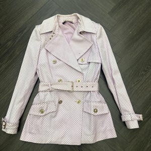 May include: A light purple trench coat with a polka dot pattern. The coat features a double-breasted design, a belt, and gold-colored buttons. The coat has two front pockets and a notched collar.
