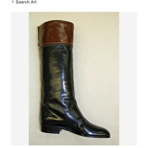 May include: A tall black leather boot with a brown leather cuff. The boot is displayed against a light background. The image is from the Metropolitan Museum of Art.