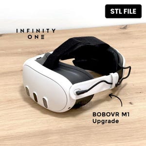 Puede incluir: Un casco de realidad virtual blanco y negro con el texto "INFINITY ONE" y "STL FILE". El casco tiene una correa negra y también es visible el texto "BOBOVR M1 Upgrade".