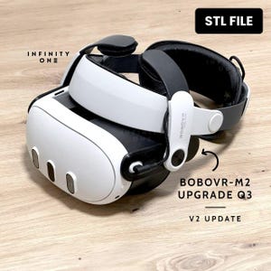 Puede incluir: Un casco de realidad virtual blanco y negro con el texto "INFINITY ONE" y "STL FILE". El casco tiene un diseño curvo con tres aberturas ovaladas en la parte delantera. También es visible el texto "BOBOVR-M2 UPGRADE Q3 V2 UPDATE".