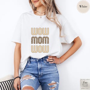 May include: White t-shirt with the text "WOW MOM WOW" in a retro font. The word "MOM" is printed in a leopard print pattern.