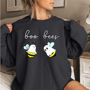 May include: A black sweatshirt with the text "boo bees" printed on the front. Two cartoon ghost bees are printed below the text.