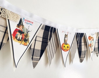 May include: A Halloween banner with a white background and black and white plaid fabric. The banner features vintage Halloween images of a girl with a black cat, an owl on a pumpkin, and a girl with a pumpkin.