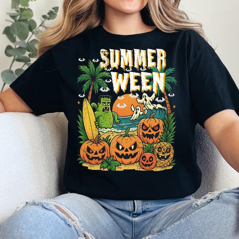 May include: Black t-shirt with a colorful graphic that reads "SUMMER WEEN". The design features a beach scene with pumpkins, ghosts, palm trees, and a monster holding a surfboard. The sun is setting over the ocean.