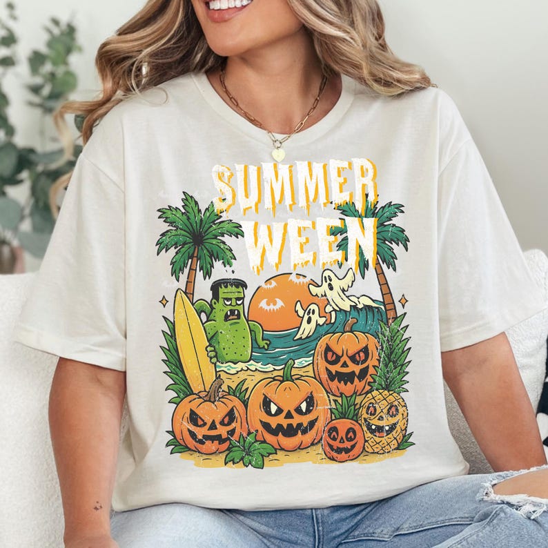 May include: Cream-colored t-shirt with a graphic that says "Summerween". The graphic features a beach scene with palm trees, pumpkins, a monster, ghosts, a surfboard, and a pineapple.