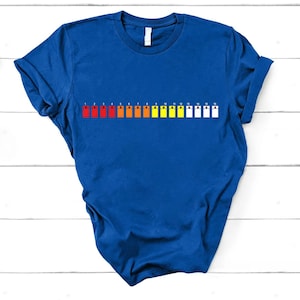 May include: Royal blue t-shirt with a pH scale graphic, numbered 1 to 15, in a gradient of colours from red to white. The tee has a crew neck and is made of a soft fabric.