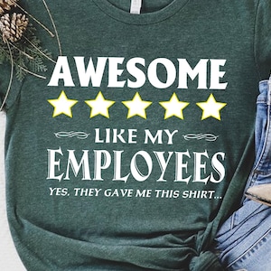 May include: Dark green t-shirt with the text "AWESOME LIKE MY EMPLOYEES" in white, along with five yellow star ratings. The phrase "YES, THEY GAVE ME THIS SHIRT..." is printed below the main text.