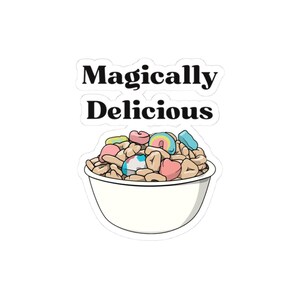 May include: A white bowl filled with a breakfast cereal with colorful marshmallows. The text "Magically Delicious" is written above the bowl.