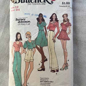 May include: A vintage Butterick sewing pattern envelope, number 6534, size 12, bust 34, featuring Betsey Johnson of Alley Cat designs. The illustration displays five variations of tops, skirts, and pants, specifically designed for knit fabrics only.