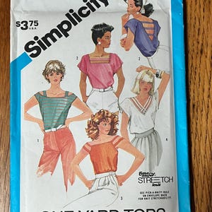May include: A Simplicity 6412 sewing pattern envelope for size 12 miss tops. The front features illustrations of four different top designs in various colors, including blue, pink, orange, and white, with the text One-Yard Tops and Time-Saver Stretch Knit.