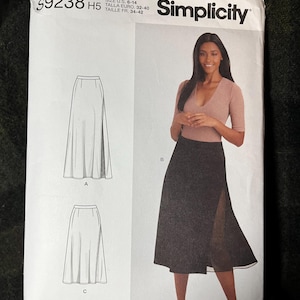 May include: Simplicity pattern S9238 for a skirt. The pattern includes a diagram of the skirt design and a photo of a woman wearing the skirt. The pattern size is U.S. 6-14.