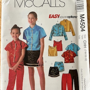 May include: A McCall's M4504 sewing pattern envelope for children's clothing. The front shows illustrations of tops, skirts, and pants in various colors and patterns, including red, blue, gold, and black. Text includes McCall's, M4504, and size CHH.
