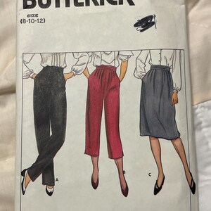 May include: A vintage Butterick sewing pattern, size 8-12, featuring illustrations of three different women's outfits: pants and a skirt. The pattern number is 4666. The outfits are in black, red, and gray.