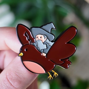 Pin de esmalte negro de mago montando un pájaro gigante