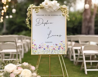 May include: A gold-framed wedding sign with a white background and floral border. The sign reads "Welcome to the wedding of Daphne & Lucas 14.08.2025".