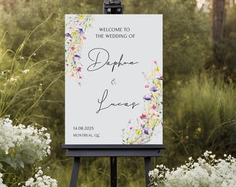 May include: A white wedding welcome sign with watercolor floral designs in shades of purple, pink, and yellow. The sign reads "Welcome to the wedding of Daphne & Lucas 14.08.2025 Montreal, QC".