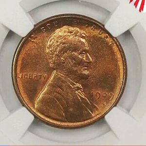 Puede incluir: Una moneda de un centavo estadounidense de cobre de 1999 con las palabras "In God We Trust" y "Liberty" inscritas en ella. La moneda presenta un perfil de Abraham Lincoln en el anverso.