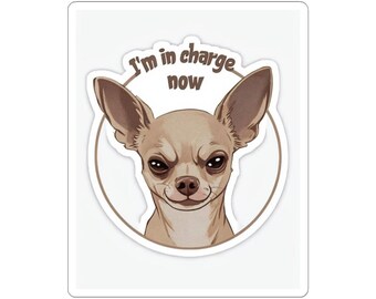 May include: A sticker featuring a cartoon chihuahua with a serious expression. The chihuahua is surrounded by a circle with the text "I'm in charge now" in brown letters.