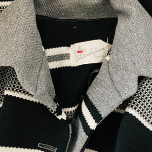 May include: Black and white striped shirt with a gray collar and a label that reads "Donovan Galvani" in white text.