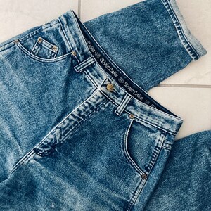 Op de afbeelding: Een lichtblauwe spijkerbroek met een vervaagde wassing. De broek heeft een hoge taille en een rechte pijp. De tailleband heeft een zwart label met de tekst "Silverlake" die twee keer wordt herhaald.
