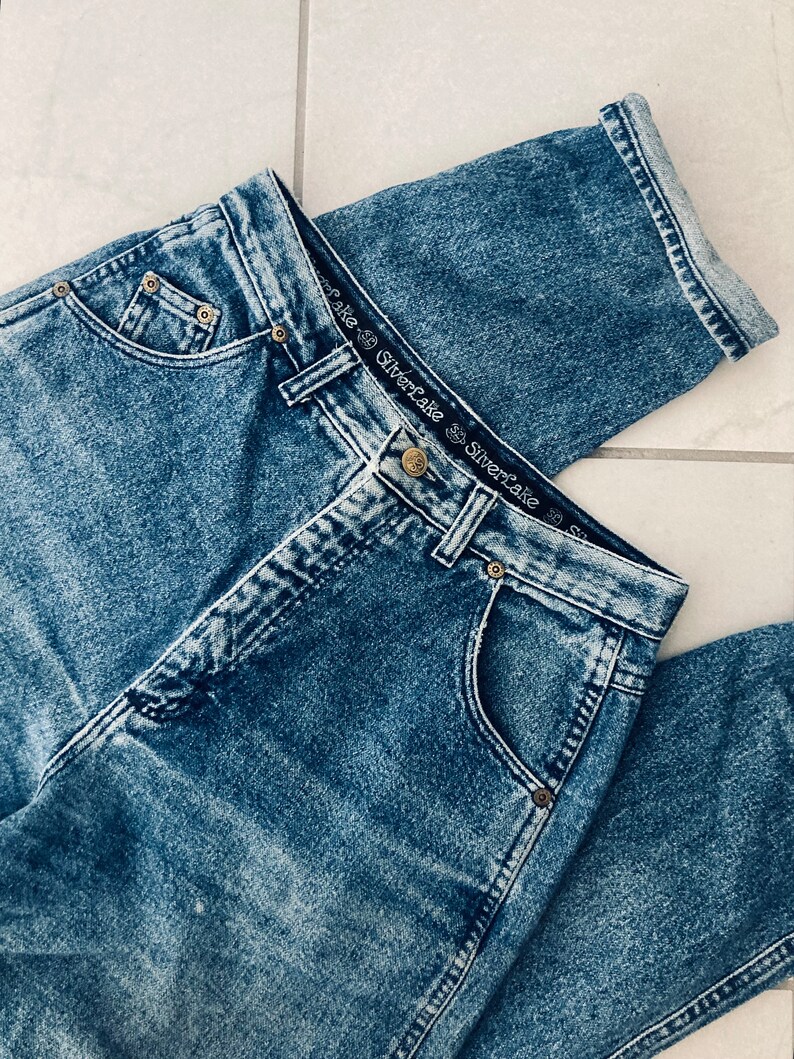 Op de afbeelding: Een lichtblauwe spijkerbroek met een vervaagde wassing. De broek heeft een hoge taille en een rechte pijp. De tailleband heeft een zwart label met de tekst "Silverlake" die twee keer wordt herhaald.