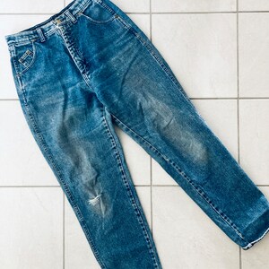 Op de afbeelding: Een lichtblauwe spijkerbroek met een gescheurde knie. De broek heeft een hoge taille en een rechte pijp.
