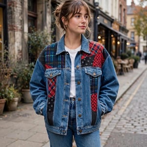 May include: A blue denim jacket featuring patchwork panels of red, black, and blue plaid and patterned fabric. The jacket has a classic collar, metal button closures, two chest pockets with flaps, and long sleeves, worn over a plain white shirt.