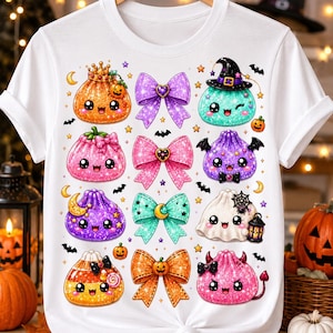 May include: A white t-shirt featuring a graphic print of various cute, glittery Halloween-themed characters and colorful bows. The design includes smiling pumpkins, a ghost, a witch hat, and small bats arranged in a grid pattern on the front.