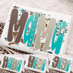 Puede incluir: Cojín rectangular blanco con la palabra "MAMA" en marrón, turquesa y beige. Las letras están adornadas con perlas de imitación y detalles turquesa. Un lazo con estampado de vaca está en el lado derecho.
