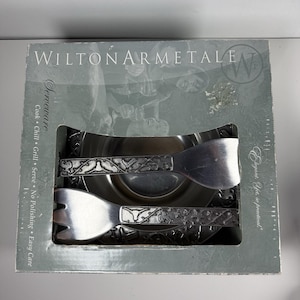 May include: A boxed Wilton Armetale serving set. The set includes a serving bowl and two serving utensils. The box is silver with the words "WILTON ARMETALE" and "Serveware" printed on it. The utensils have a decorative pattern.
