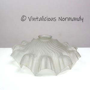 Könnte beinhalten: Lampenschirm aus mattiertem Glas mit gerüschtem Rand. Der Schirm hat ein wellenförmiges, strukturiertes Design und einen ausgestellten, gewellten Rand. Der Text "© Vintalicious Normandy" ist oben sichtbar.