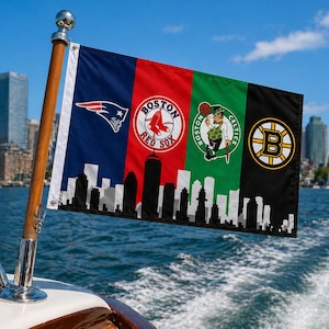 Pode incluir: Uma bandeira com quatro pain&eacute;is verticais com os logotipos das equipas desportivas de Boston: Patriots, Red Sox, Celtics e Bruins. A bandeira est&aacute; montada num mastro de madeira num barco, com uma silhueta da cidade na parte inferior. C&eacute;u azul e &aacute;gua.