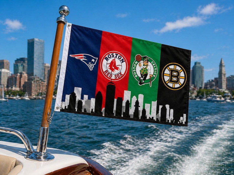 Pode incluir: Uma bandeira com quatro pain&eacute;is verticais com os logotipos das equipas desportivas de Boston: Patriots, Red Sox, Celtics e Bruins. A bandeira est&aacute; montada num mastro de madeira num barco, com uma silhueta da cidade na parte inferior. C&eacute;u azul e &aacute;gua.