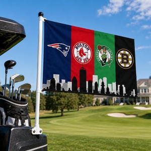 Pode incluir: Uma bandeira com os logotipos dos New England Patriots, Boston Red Sox, Boston Celtics e Boston Bruins. A bandeira est&aacute; presa a um carrinho de golfe em um campo de golfe. A parte inferior da bandeira tem um horizonte em preto e branco.