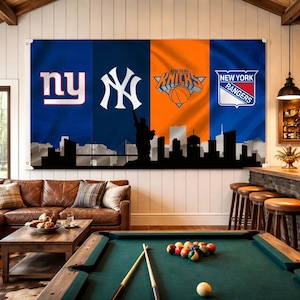 May include: A large wall hanging featuring the logos of four New York sports teams: the Giants, Yankees, Knicks, and Rangers. The design includes a silhouette of the New York City skyline. The room also has a pool table, leather sofa, and bar.