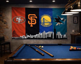 May include: A large wall banner featuring the logos of the San Francisco 49ers, San Francisco Giants, Golden State Warriors, and San Jose Sharks. A cityscape silhouette is at the bottom. A pool table with blue felt and pool cues is in the foreground.