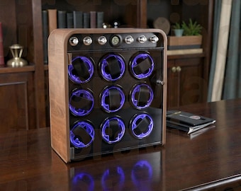 May include: A wooden watch winder with a glass door, featuring nine watch holders illuminated by blue lights. The winder has a digital display and is set on a dark wooden surface.