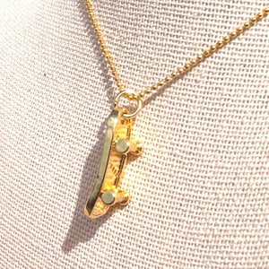 Collier doré à breloques skateboard